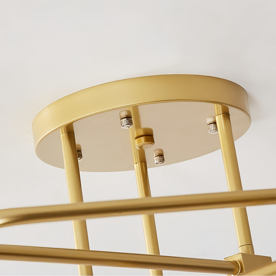 Close-up detail of gold semi flush mount light showing circular canopy with extending brass arms
