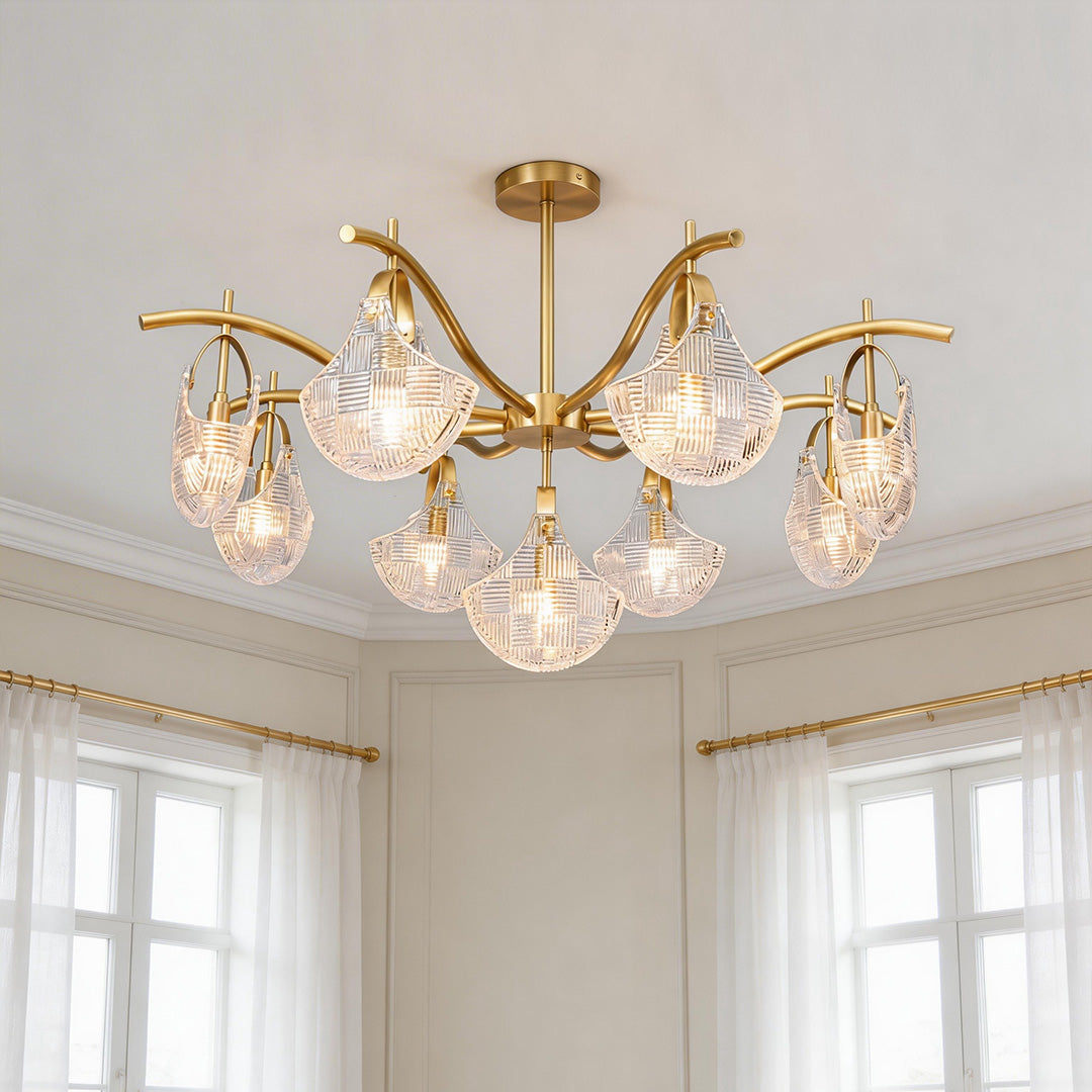 Elegant gold shell chandelier light featuring curved brass arms and textured clear glass shades in a bright room.