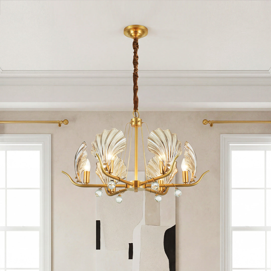 Elegant gold shell chandeliers featuring fluted glass shades and crystal teardrop accents in a sophisticated room.
