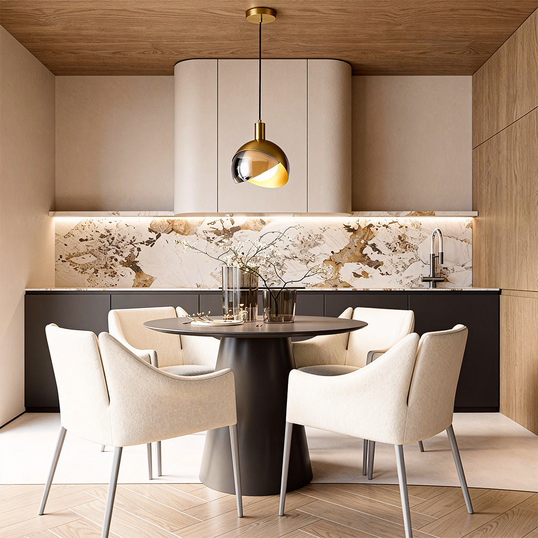 Gold sphere pendant light hanging above a round dining table in a contemporary kitchen space.