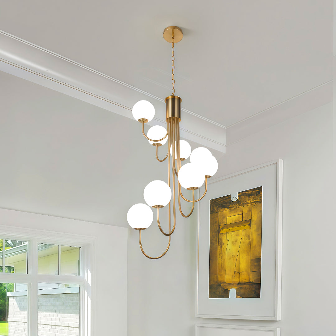 Gold spiral globe chandelier installed in a bright white living room for a contemporary look.