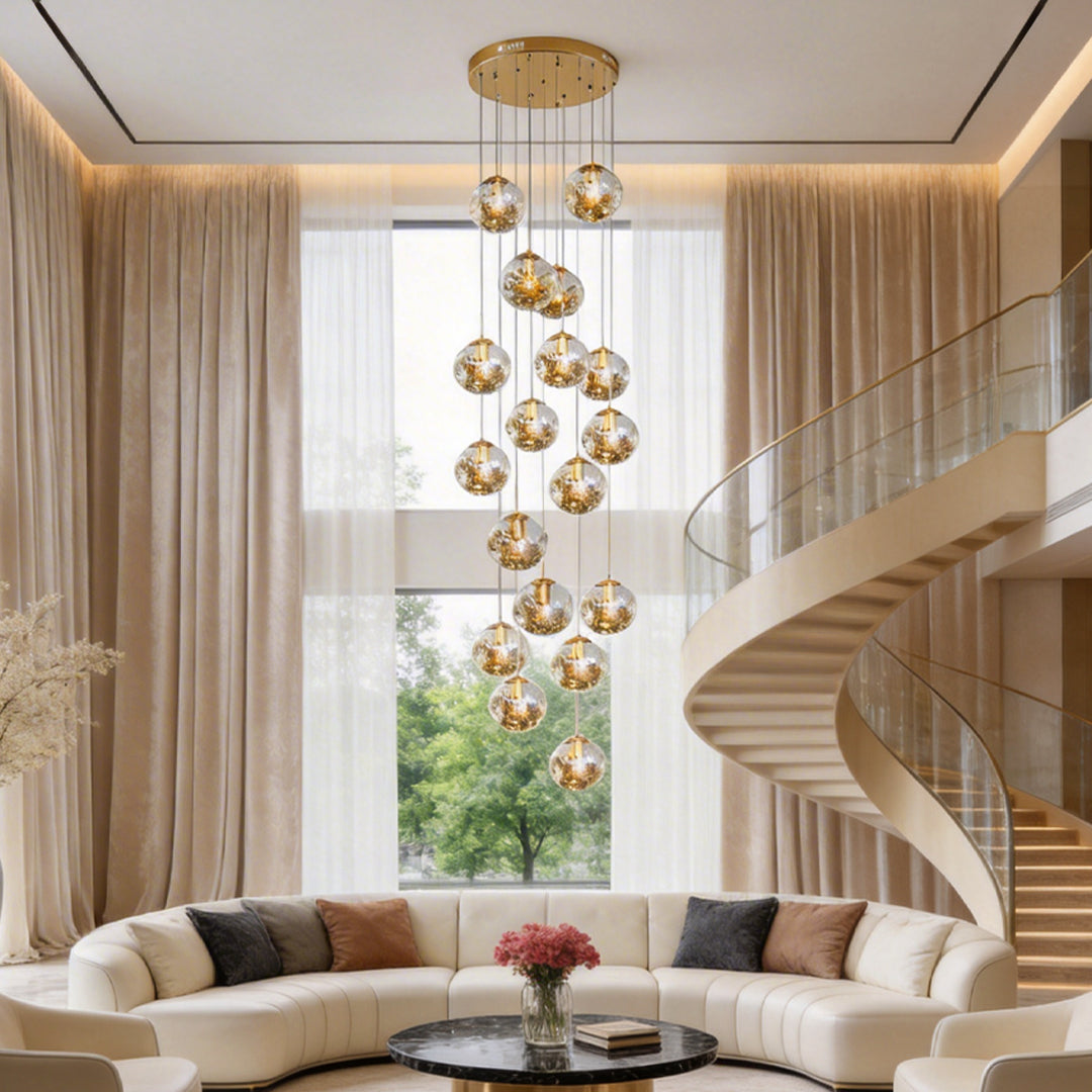 Gold staircase chandelier with cascading crystal spheres, elegantly illuminating a modern spiral staircase.