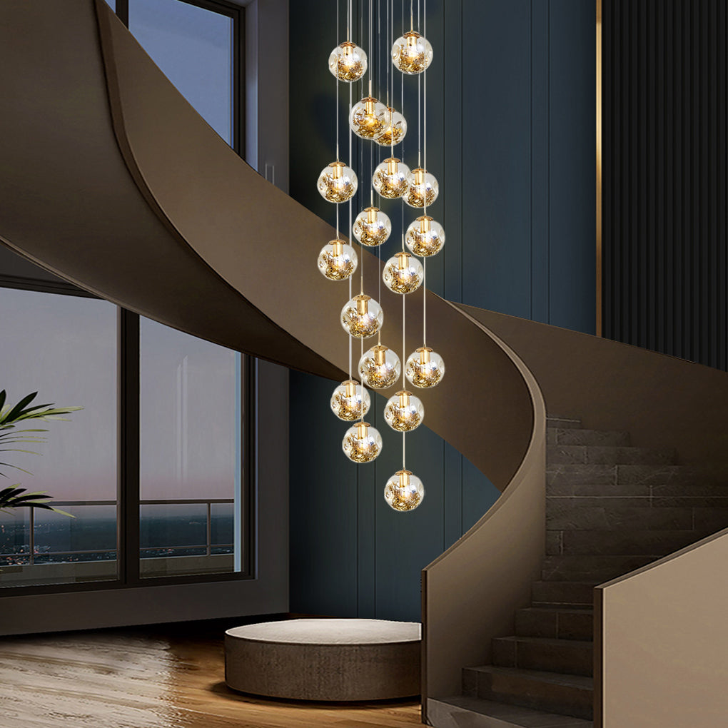Gold staircase chandelier with a close-up of its glowing crystal spheres.