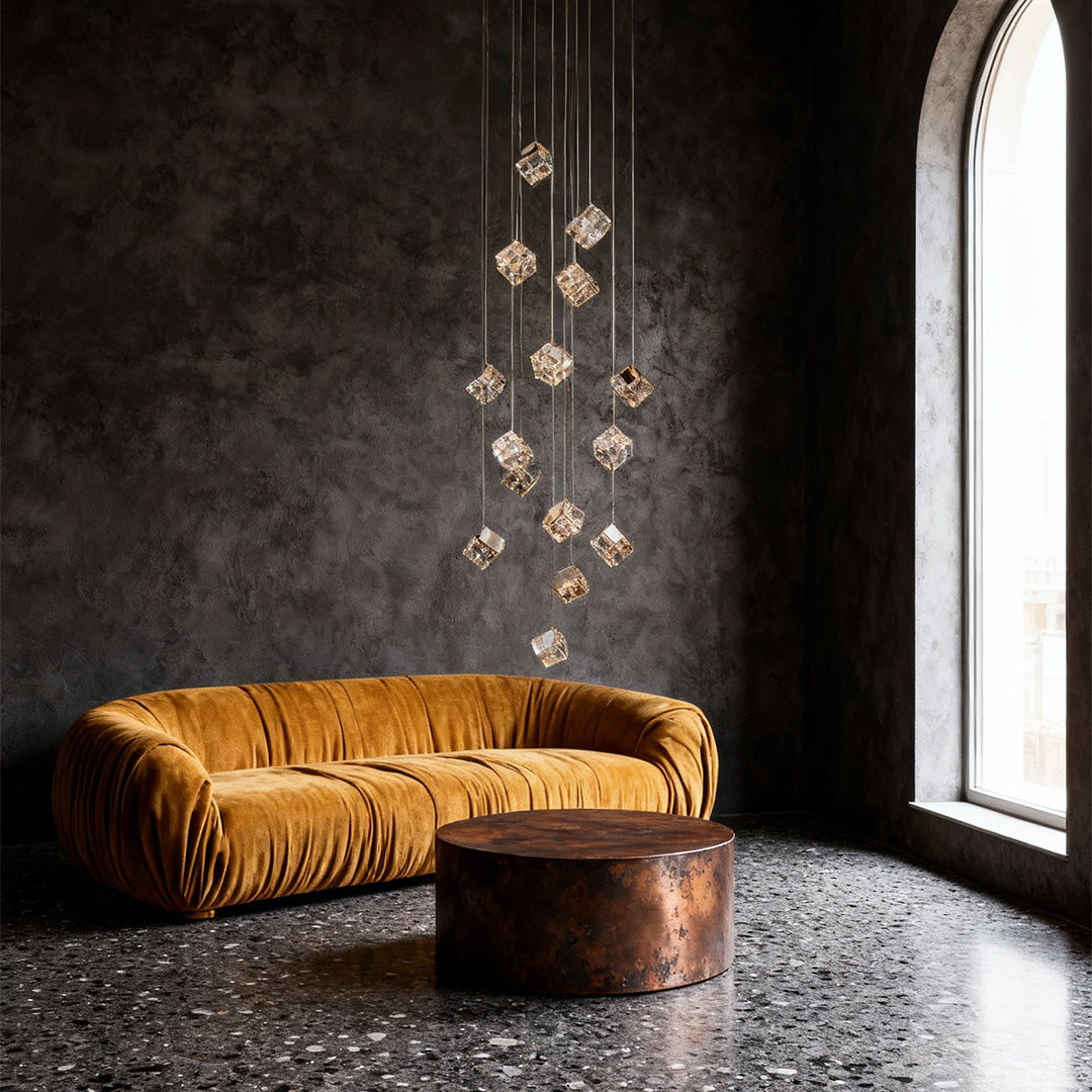 Gold cube chandelier suspended beside curved staircase in luxury foyer.