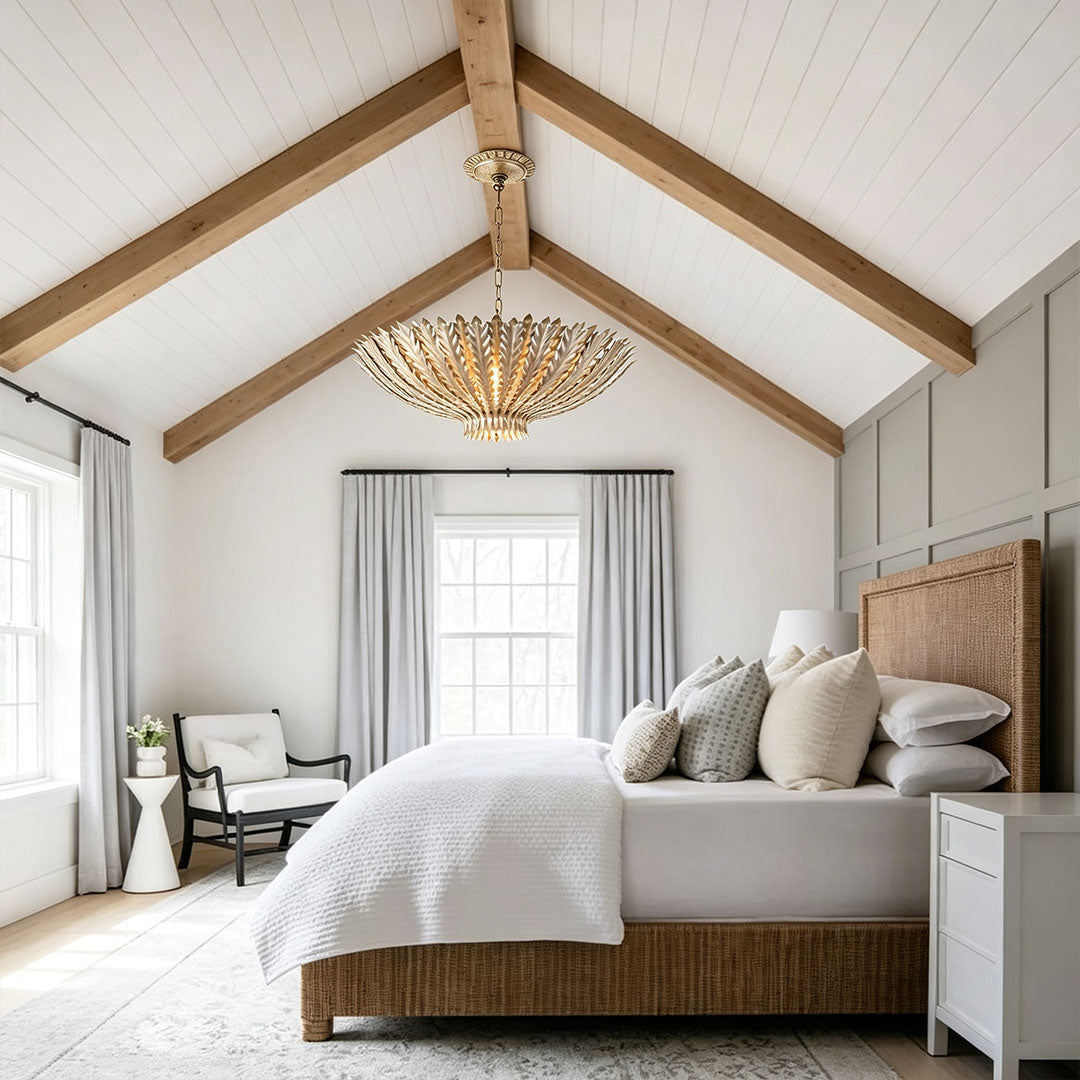 Gold vintage chandelier hanging in a modern farmhouse bedroom with vaulted ceiling beams.