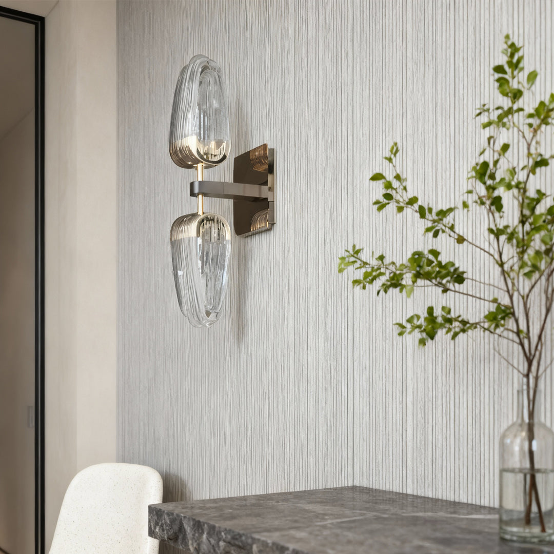 Gold wall light installed in bright minimalist bathroom with textured concrete walls creating ambient side lighting