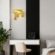 Gold wall light adding elegance to white bedroom workspace with grey bedding and houseplant