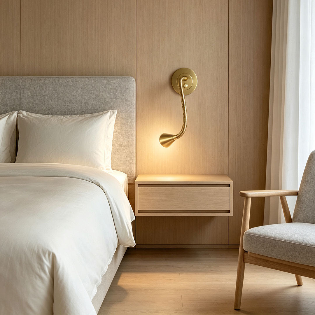 Gold wall light with swing arm mounted above a floating bedside table.