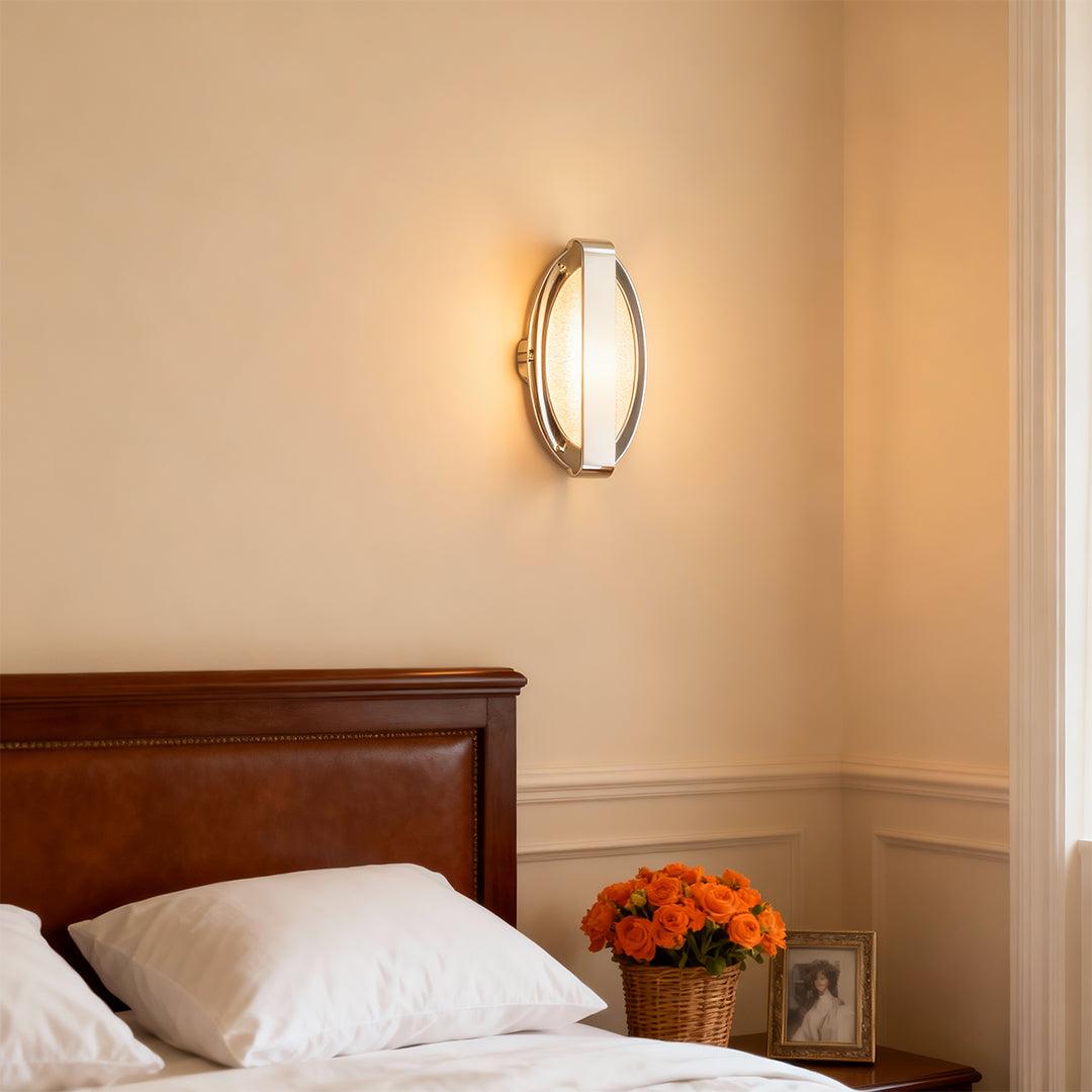 Gold wall lights providing warm bedside lighting above wooden headboard in cozy traditional bedroom