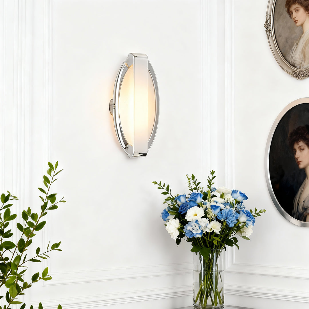 Gold wall lights illuminating bright white interior space with fresh flowers and natural daylight