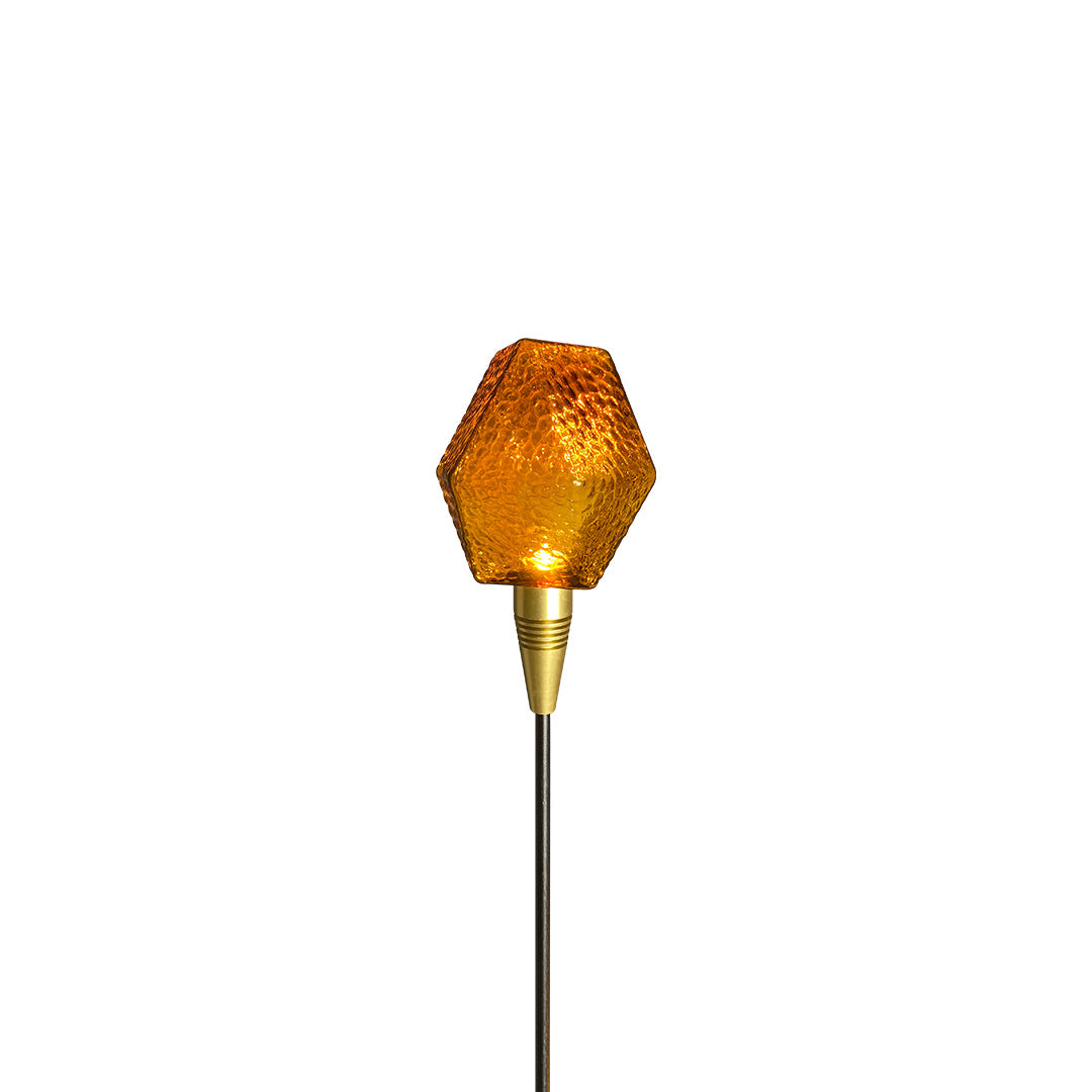 Gold-toned globe stake light styled for elegant outdoor décor, shining softly as landscape lighting pathway.