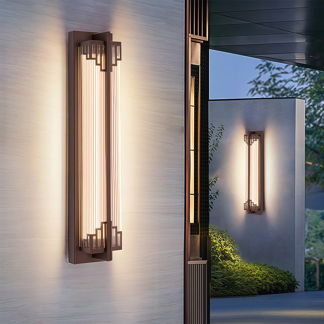 Golden LED outdoor light fixture installed on a stone wall, casting a soft, inviting light.