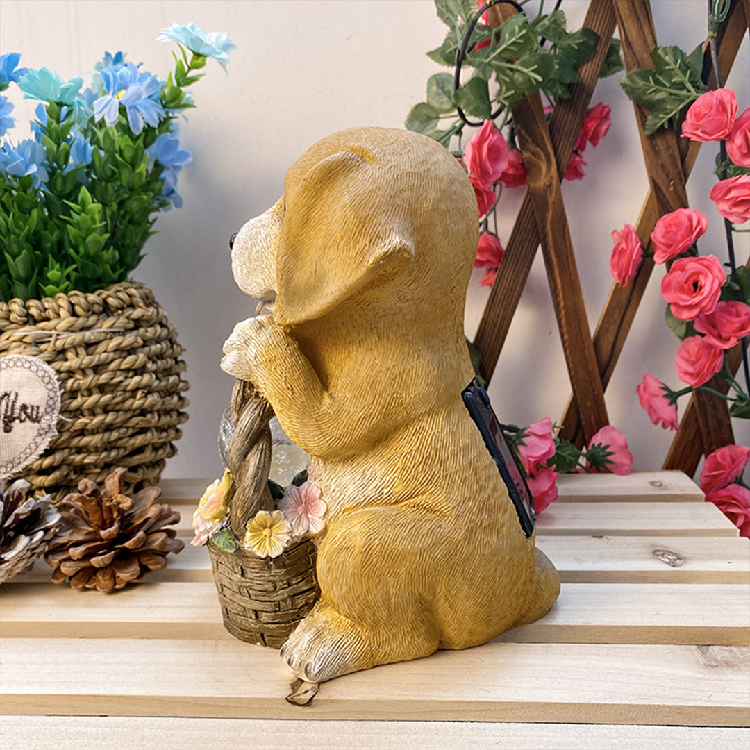 Golden puppy figurine in sitting position holding decorative welcome sign among artificial flowers