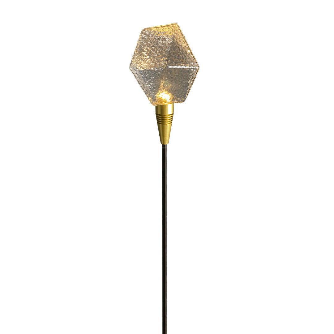 Golden globe stake light with warm shimmer, adding elegance to outdoor landscape lighting pathway scenes.