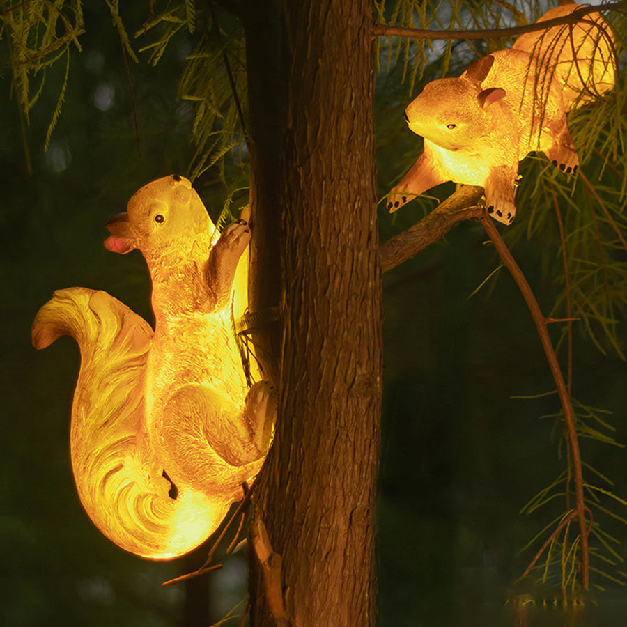 Golden solar-powered squirrel decorative light mounted on wooden post for outdoor pathway lighting