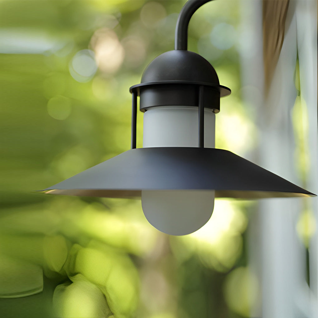 Gooseneck wall light fixtures providing soft lighting in a garden pathway setting.