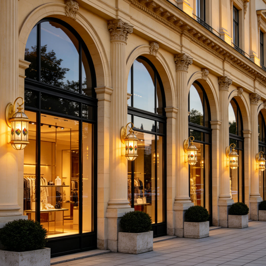 Grand building exterior enhanced with warm glowing Outdoor Lantern Wall Lights mounted beside tall arched windows.