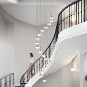 Elegant chandelier for tall ceilings providing ambient lighting in grand hallway with multiple glass orb pendants