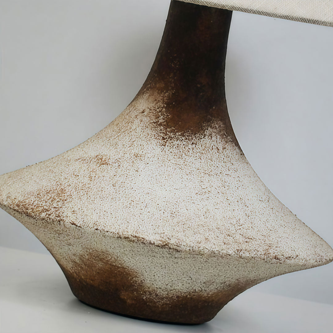 Close-up of a gray ceramic table lamp base showing the sculptural form and textured glazed finish.