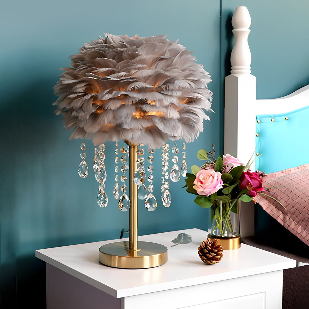 Gray feather table lamp with gold base styled in a modern bedroom.