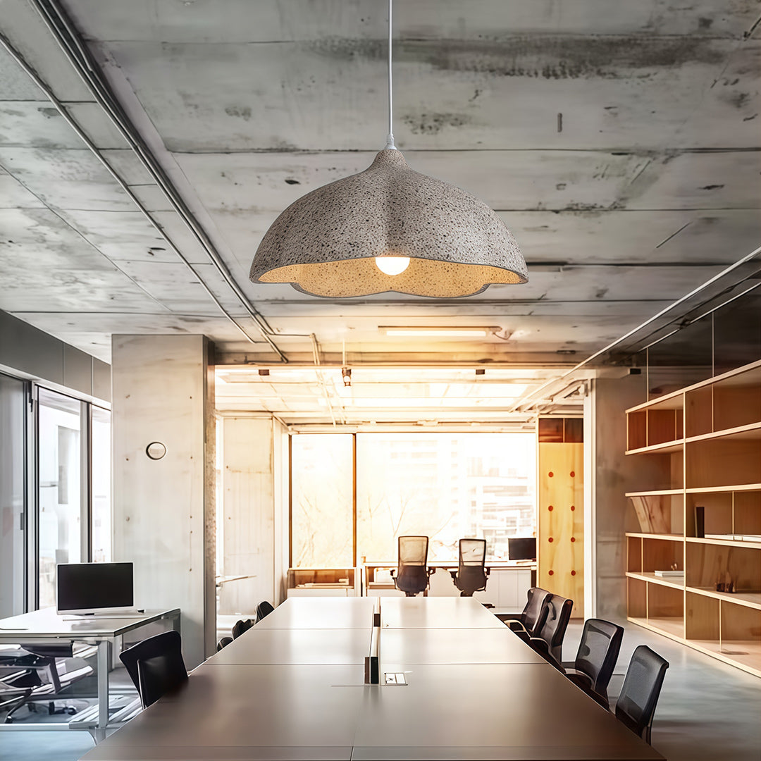 Gray vintage metal pendant light above long dining table in industrial-style restaurant.