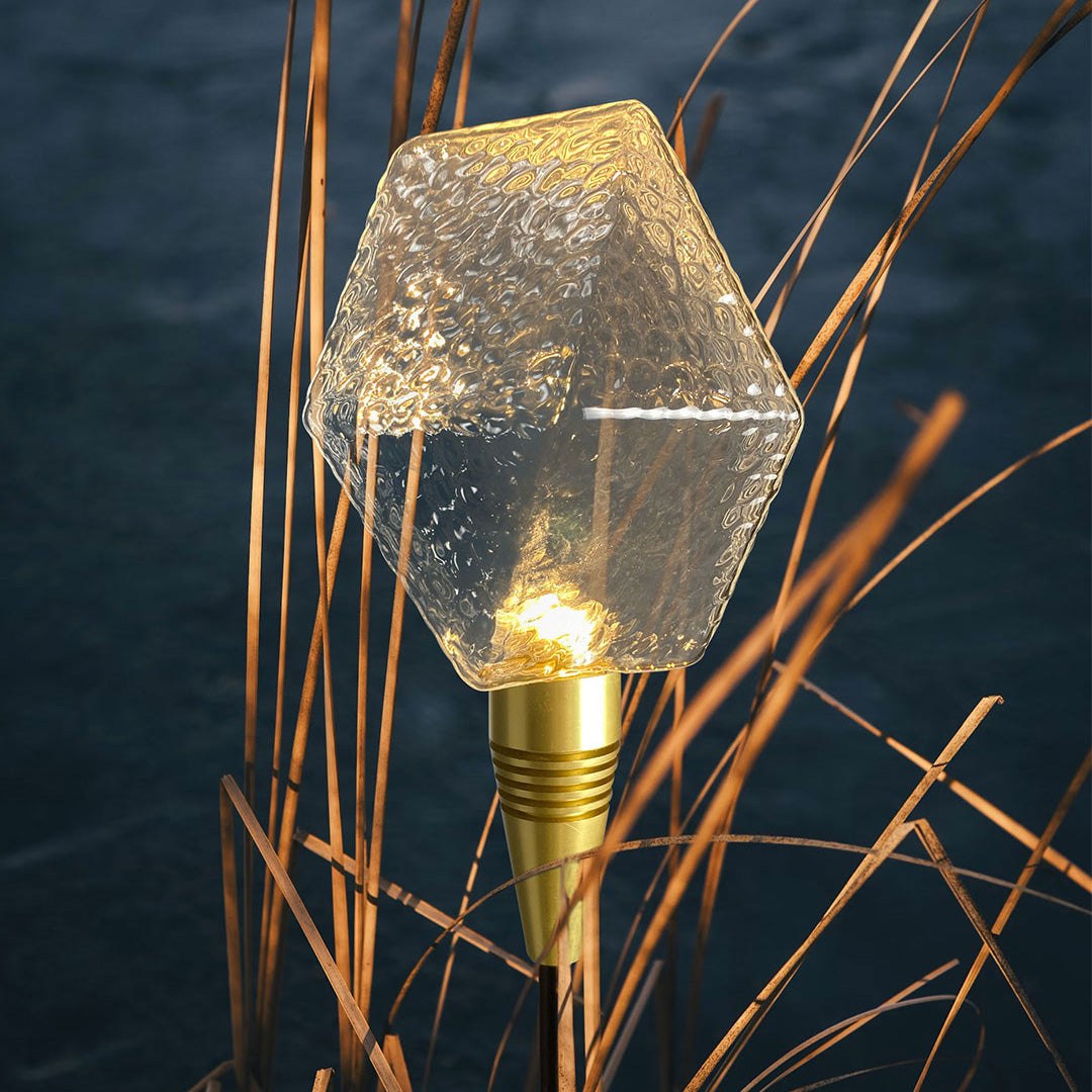 Green crystal globe garden stake illuminating a walkway, used as a stylish landscape lighting pathway feature.