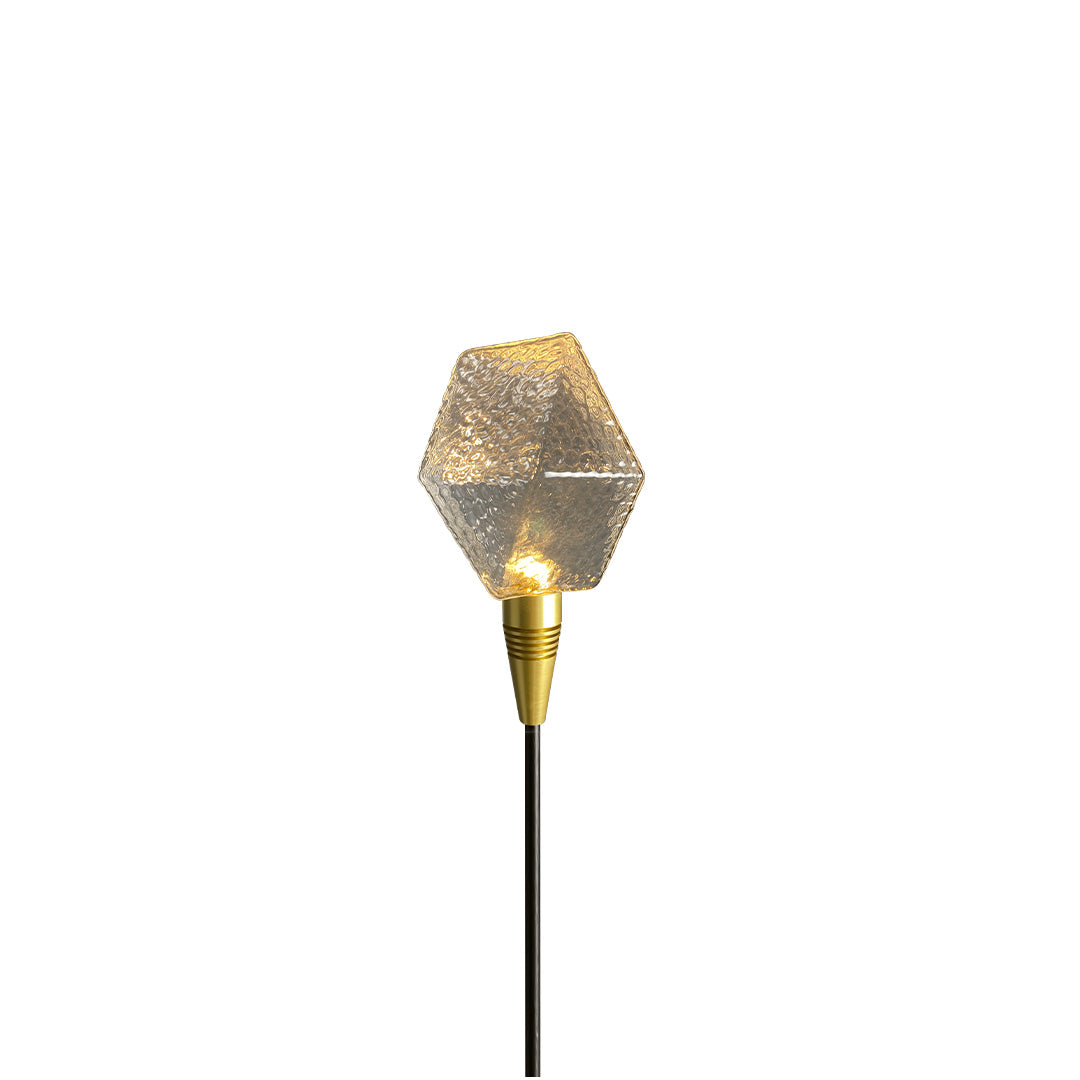 Green patterned globe stake light enhancing nighttime garden ambiance as landscape lighting pathway.