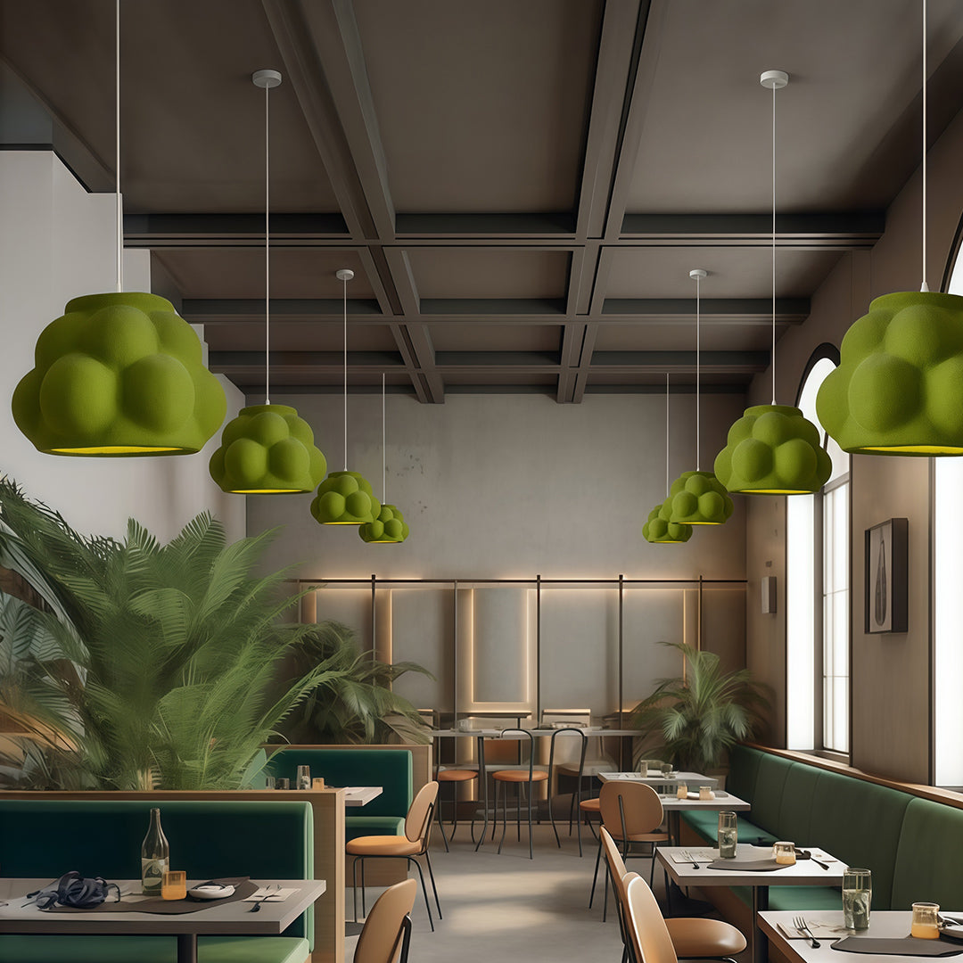Green Single Pendant Light Fixtures in modern café interior with plants and warm atmosphere.