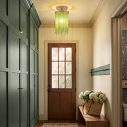 Green tassel chandelier flush mount lighting a narrow entry hallway with sage built-in cabinets and a wood front door.