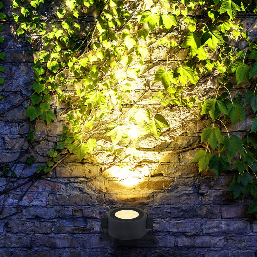 Ground-mounted waterproof LED spotlight creating dramatic uplighting effects in nighttime landscape