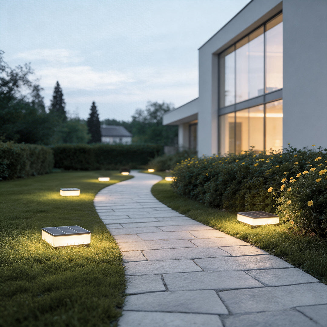 Ground solar lights illuminating a modern garden pathway with warm directional glow.
