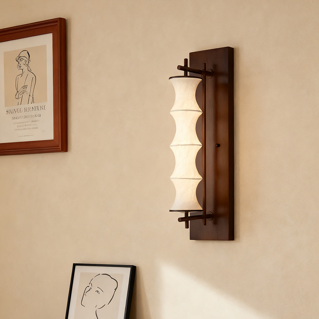 Single vintage light wall fixture mounted on a light wall near an archway, ideal for hallways or formal dining room settings.