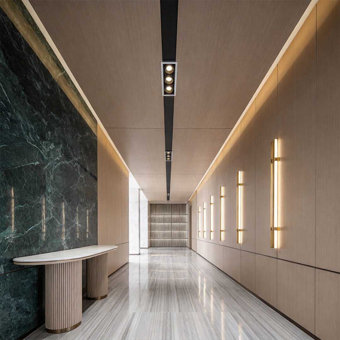 Long hallway interior with marble accents and sleek led spotlight indoor along ceiling.