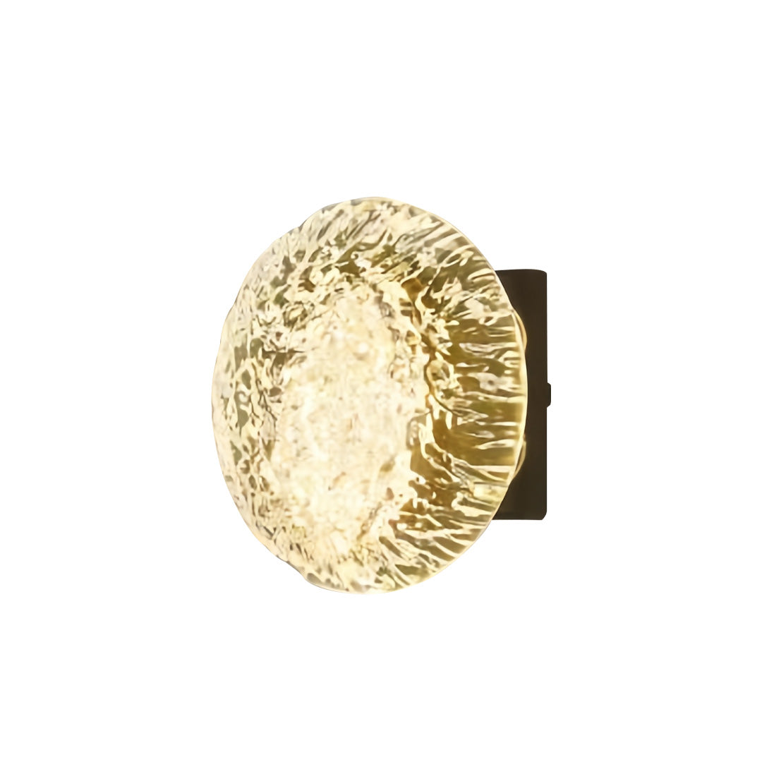 Round hammered-gold up and down outdoor wall lights showcased alone with bright warm glow.