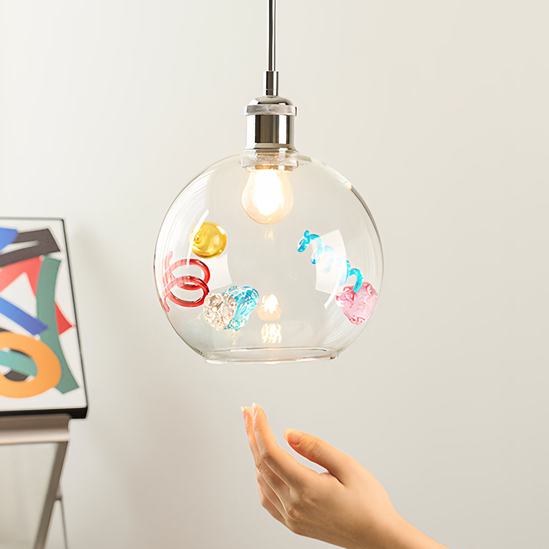 Hand-finished coloured glass pendant lights featuring abstract swirl designs and a chrome cap detail.