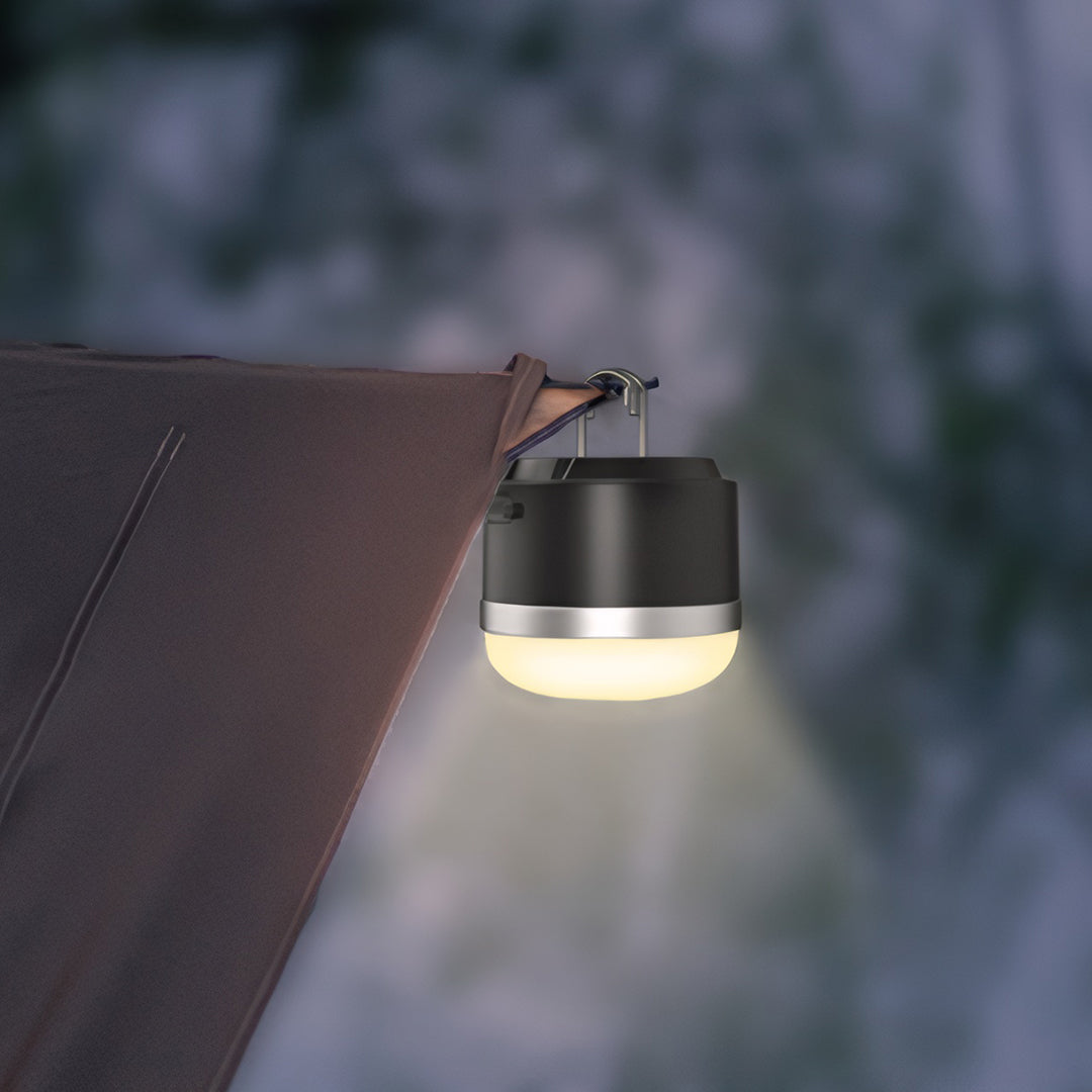 Hanging camp light providing warm illumination inside tent during evening outdoor activities