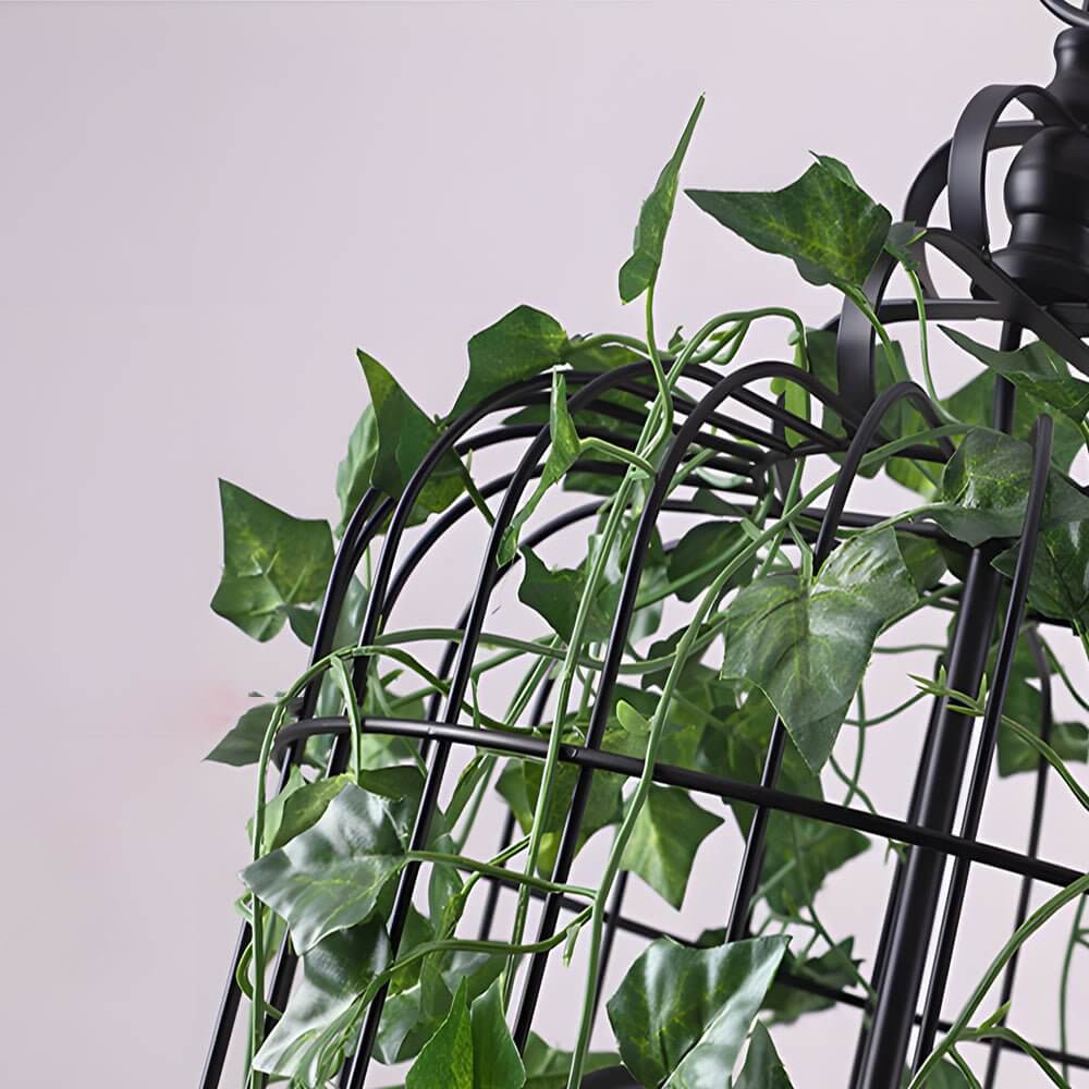 Hanging greenery with lights, close-up view of lush leaves and twinkling fairy lights.