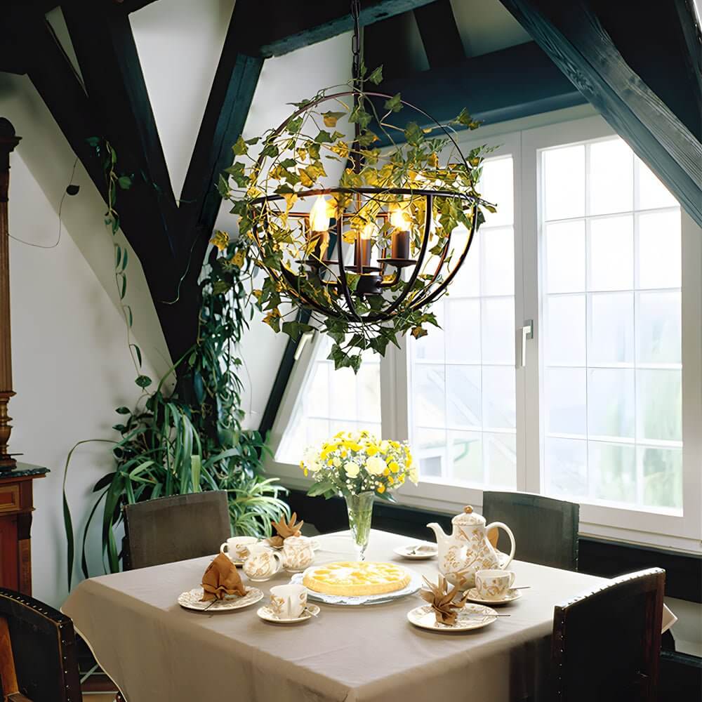 Hanging greenery with lights cascading over a wooden table in a farmhouse dining room.