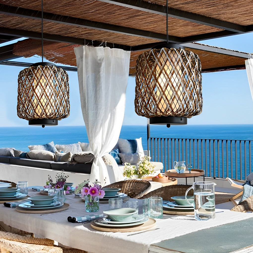 Hanging lantern lamp illuminating outdoor dining table with ocean view.