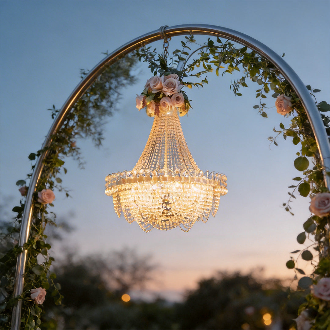 Hanging light outdoor with crystal details, illuminating a garden archway at sunset.