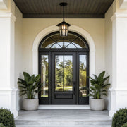 Hanging outdoor light with a classic design, mounted above a modern arched doorway.