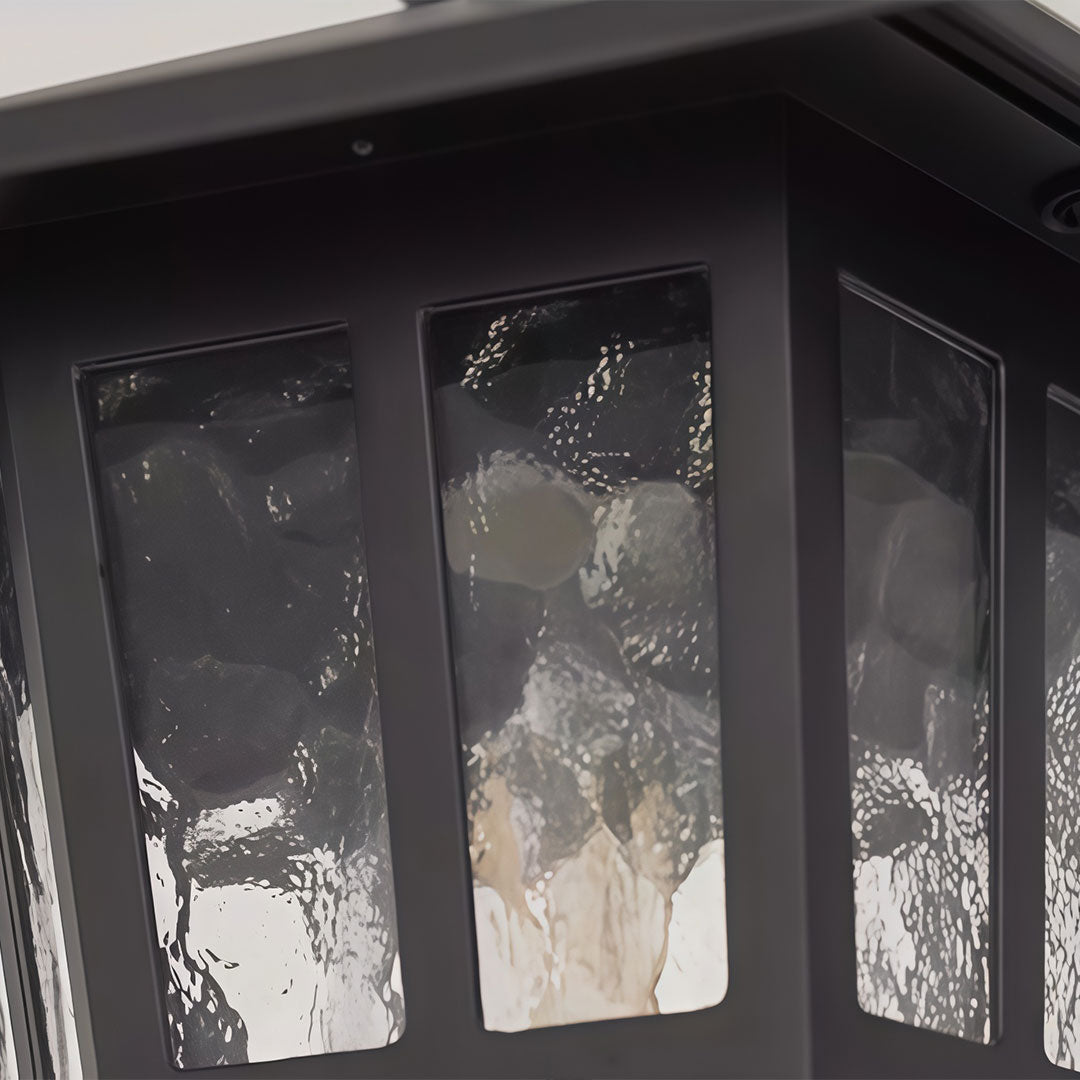 Hanging outdoor light with a classic design, providing warm illumination.