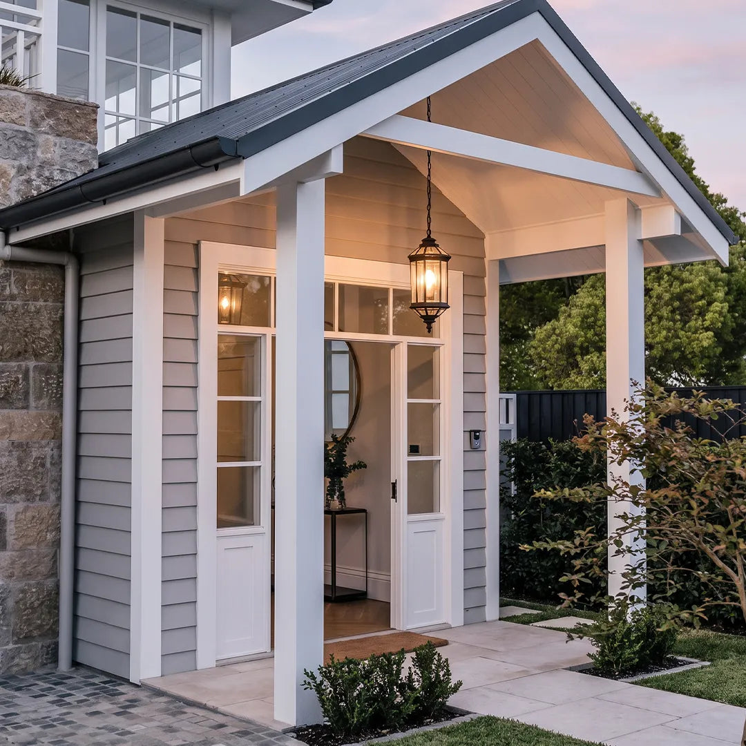 Hanging outdoor pendant lights on a small covered porch with white siding and a gabled roof.