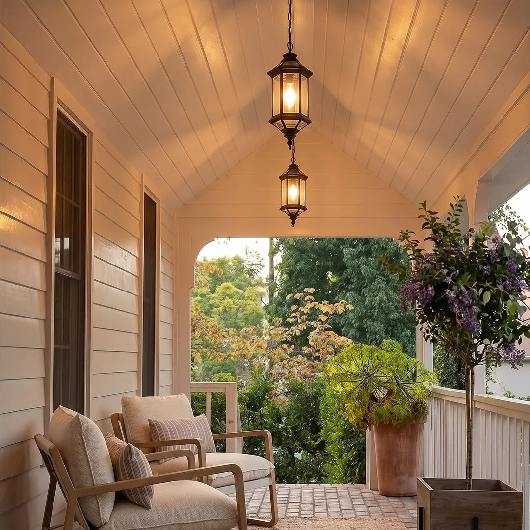 Hanging outdoor pendant lights installed along a long covered porch with lounge chairs and wood ceiling.