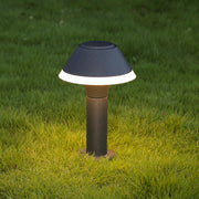 Contemporary hat-style bollard creating warm ground illumination on lawn area