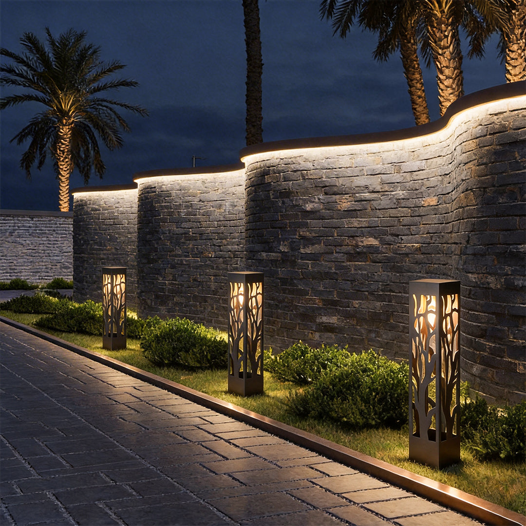 Hollow outdoor landscape lighting lining stone wall driveway with warm ambient illumination.