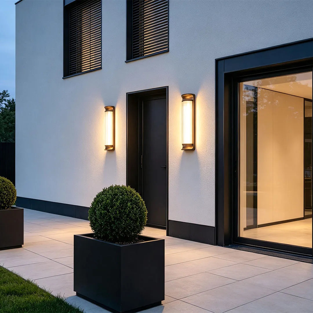 Modern LED outdoor wall sconces illuminating a contemporary home entrance at night.