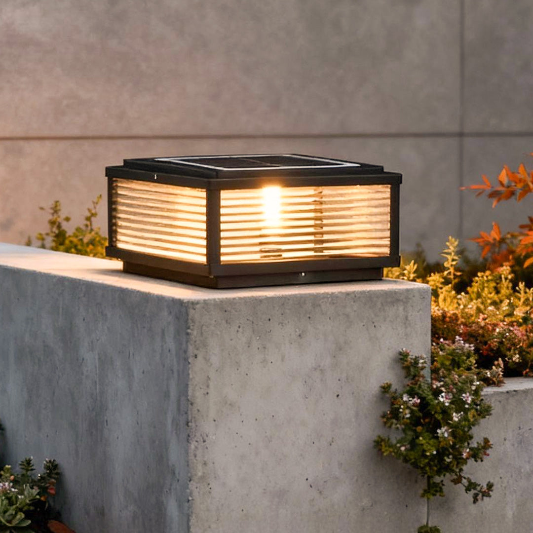 Square pillar light with horizontal slats, mounted on concrete pillar for warm and modern outdoor pathway illumination