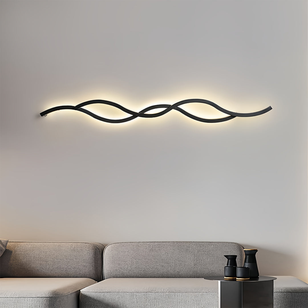 Horizontal wave-shaped LED bedside wall light illuminating the living room sofa area with warm light.