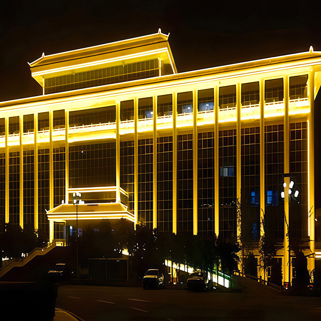 Hotel exterior illuminated by square wall wash light in golden tones.